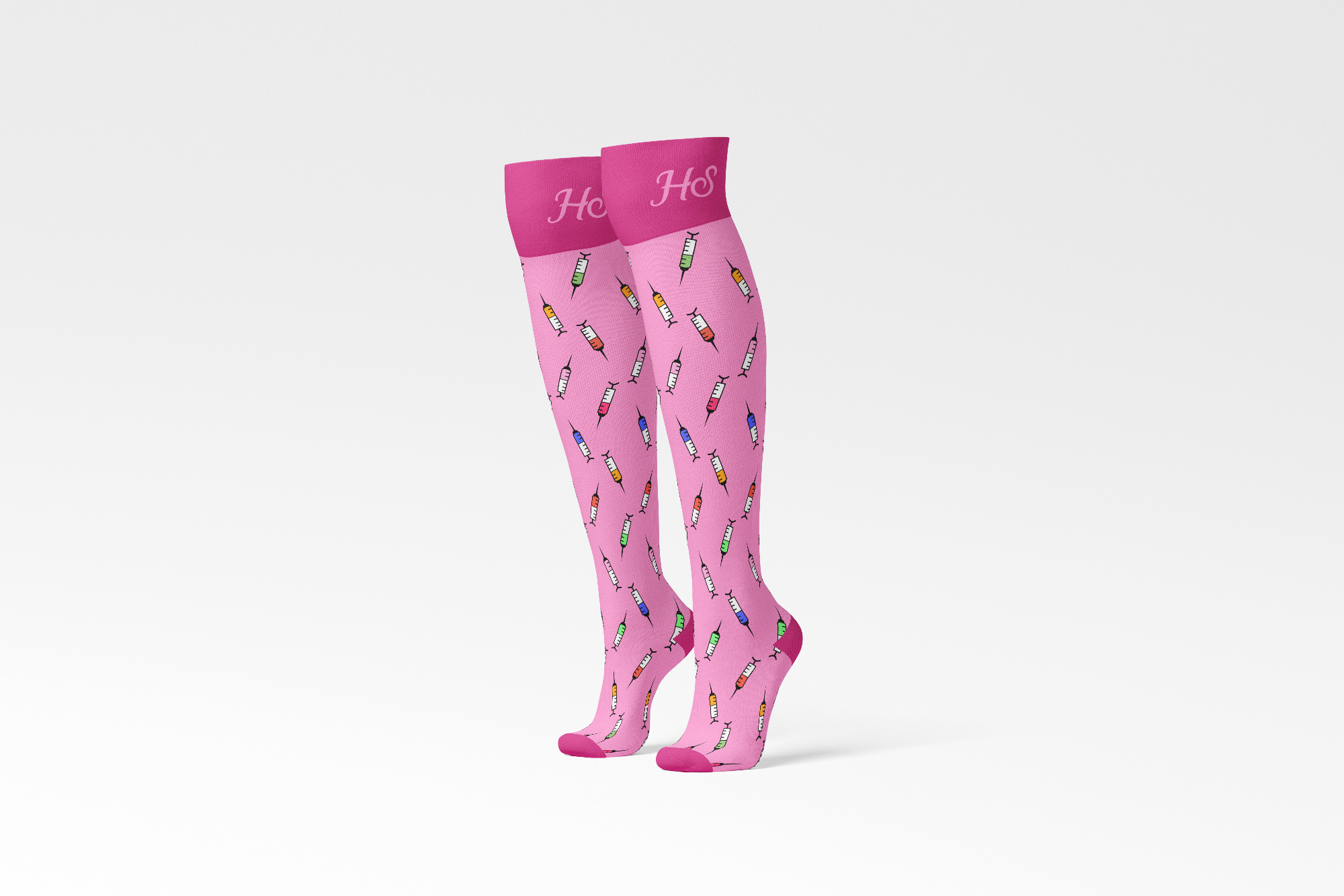 A pair of pink compression socks with colorful syringe patterns and a logo on the top.
